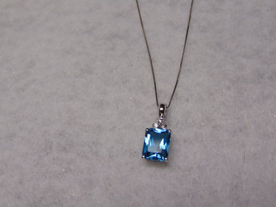 14KTWG Blue Topaz Necklace: Emerald Cut Diamond Accent